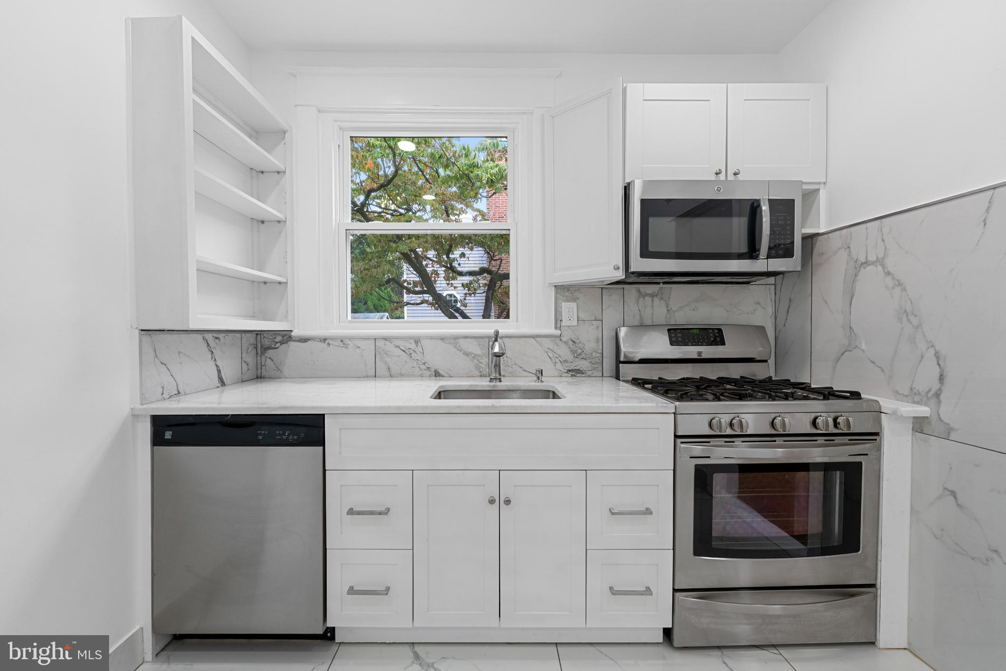 407 Sanger Street Philadelphia, PA 19120 - Photo 3 of 47 a kitchen with white cabinets stainless steel appliances and sink