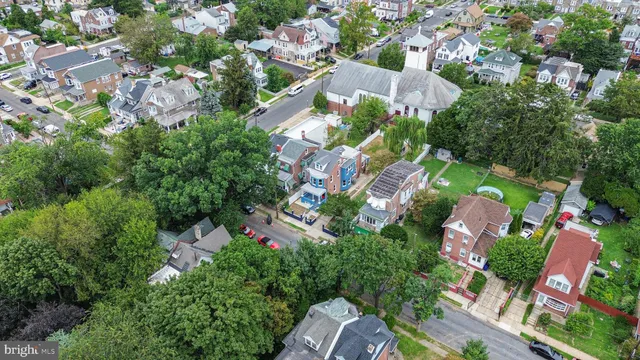 an aerial view of residential houses with outdoor space and trees