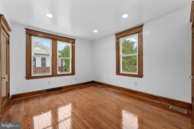 an empty room with wooden floor and a bathroom
