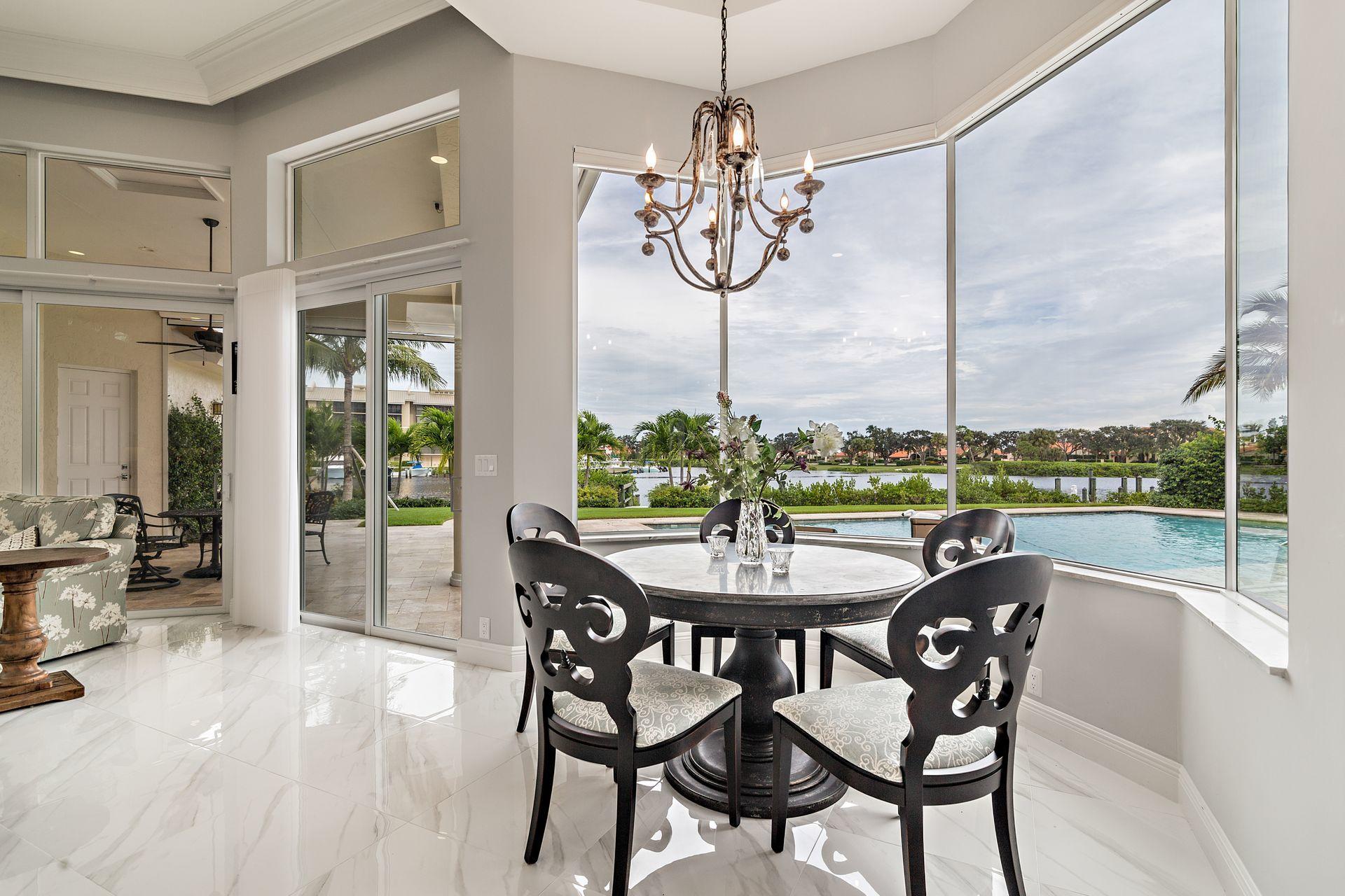3376 Barrow Island Road Jupiter, FL 33477 - Photo 16 of 48 a dining room with furniture a chandelier and wooden floor