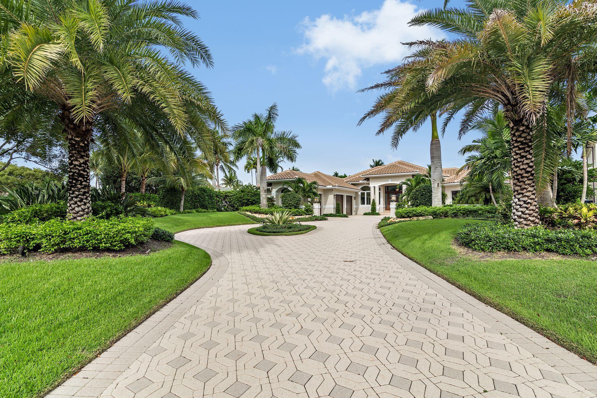 3376 Barrow Island Road Jupiter, FL 33477 - Photo 3 of 48 a view of a white house with a yard and palm trees