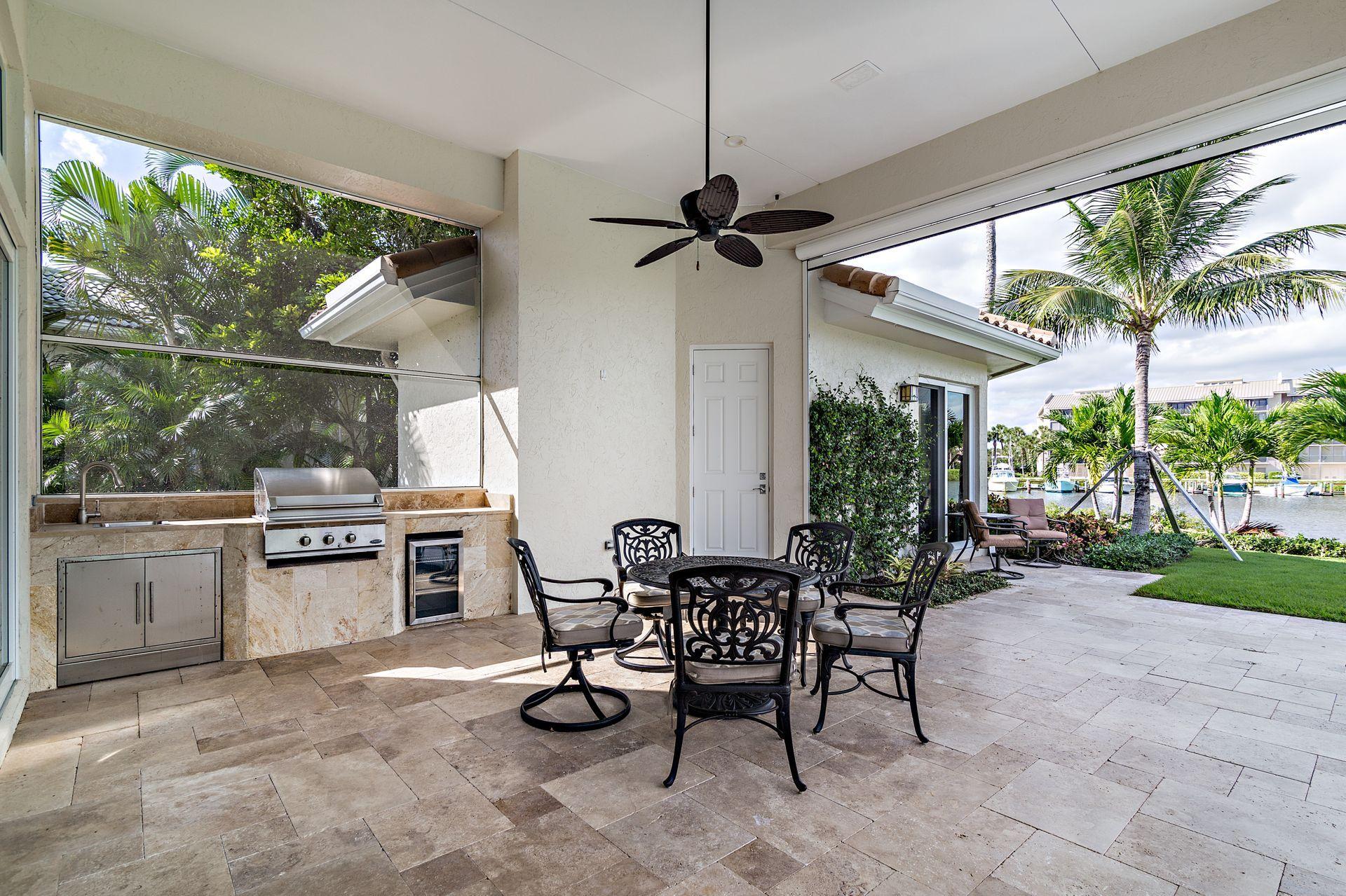 3376 Barrow Island Road Jupiter, FL 33477 - Photo 30 of 48 a view of a patio with a table and chairs