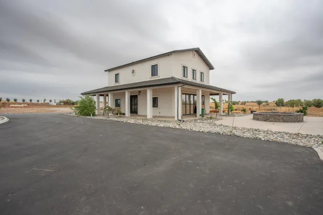 a front view of a house with a yard and lake view