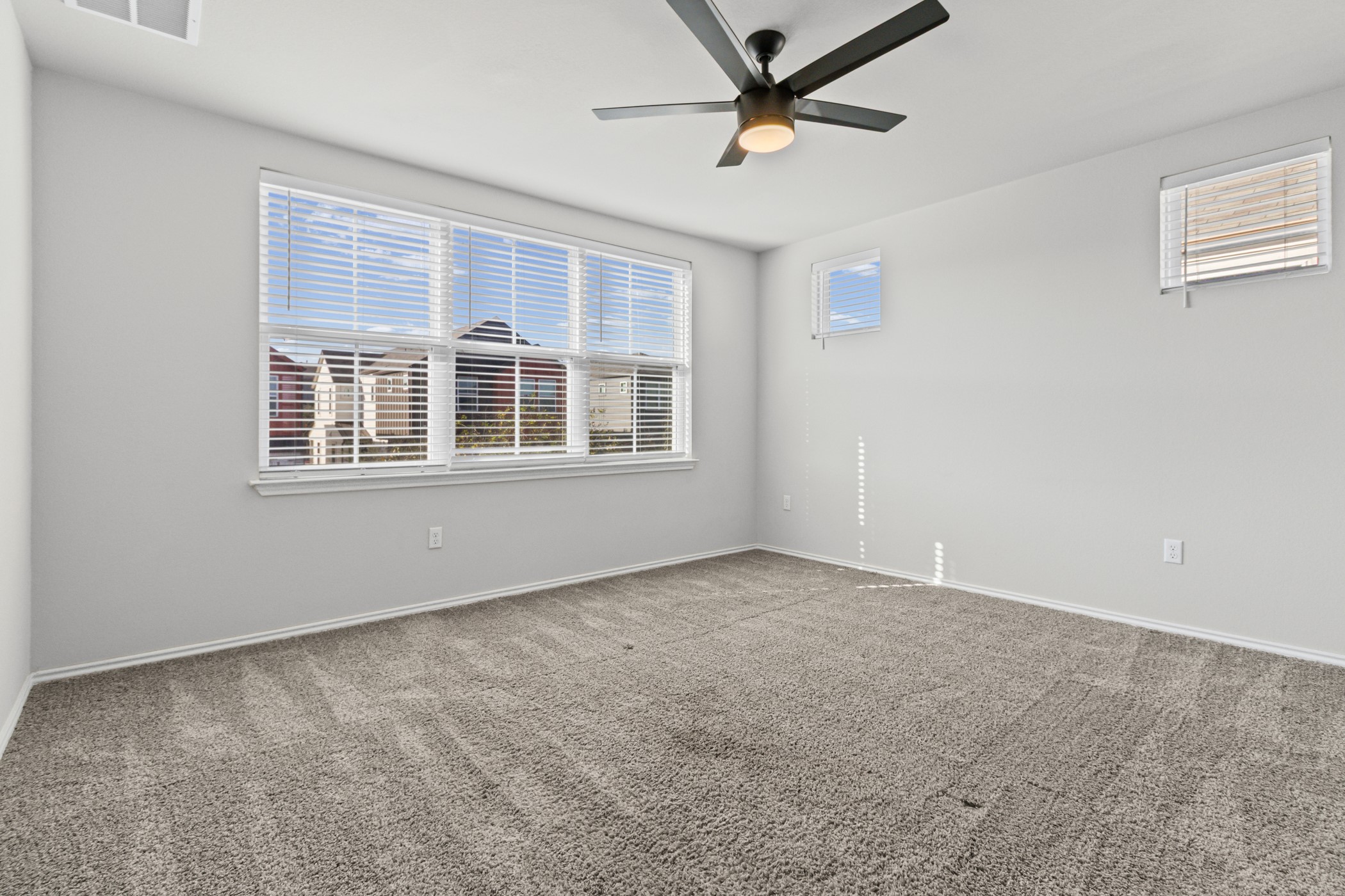 7116 Silver Star Lane, Unit 75 Austin, TX 78744 - Photo 11 of 35 Unfurnished room featuring healthy amount of natural light, carpet floors, and ceiling fan