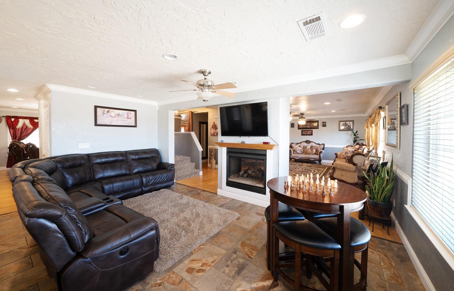 21197 Steward Road Madera, CA 93638 - Photo 13 of 41 a living room with furniture a fireplace and a flat screen tv
