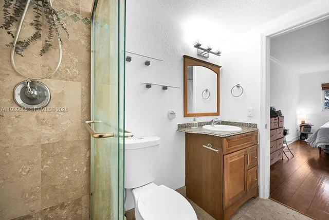 a bathroom with a granite countertop sink toilet and shower