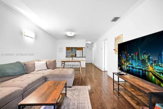 a living room with furniture and a wooden floor