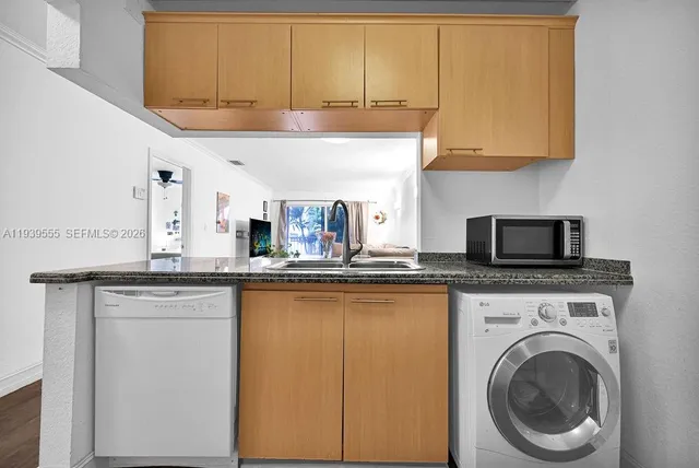 a kitchen with granite countertop white cabinets and a sink