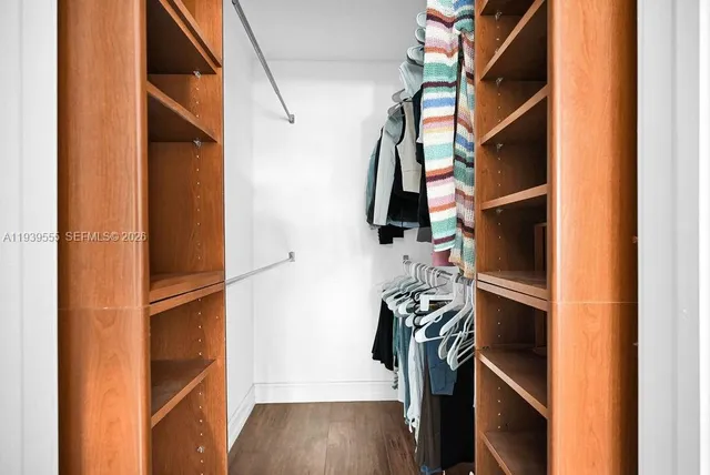 a view of walk in closet with clothes and shoes