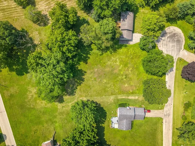 an aerial view of residential house with outdoor space and trees all around