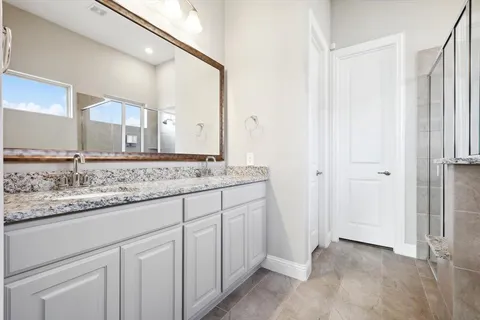 a bathroom with a granite countertop sink and a mirror