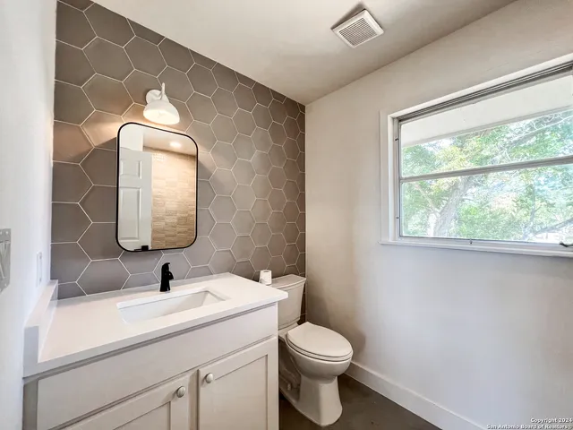 a bathroom with a toilet sink and mirror