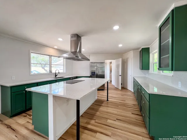 a large kitchen with stainless steel appliances a large window in it