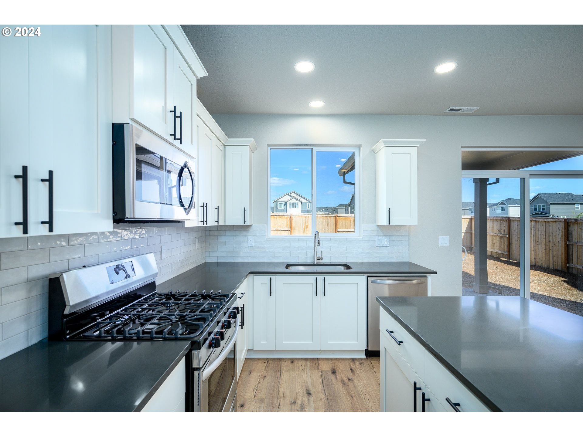 123 North 88th Drive, Unit 53 Ridgefield, WA 98642 - Photo 37 of 46 a kitchen with stainless steel appliances granite countertop a stove a sink dishwasher and cabinets with wooden floor