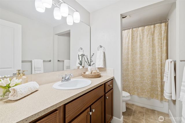 a bathroom with a granite countertop sink a toilet and a mirror