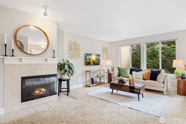 a living room with furniture a fireplace and a large window