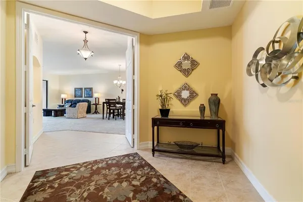 a view of a dining room and livingroom with furniture a chandelier and kitchen view