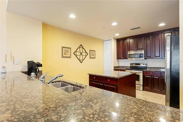 a bathroom with a granite countertop sink toilet mirror and bathtub