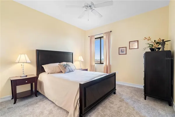 a spacious bedroom with a bed table and window