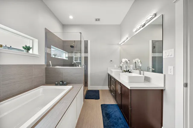 a bathroom with a bathtub a double vanity sink and mirror