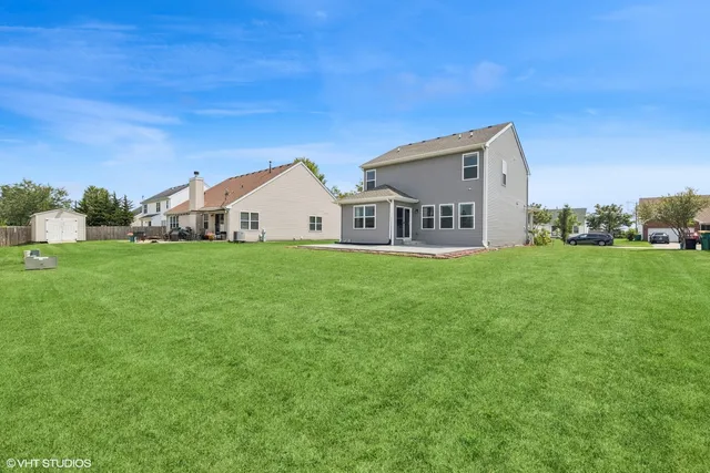 a view of a house with a yard and sitting area