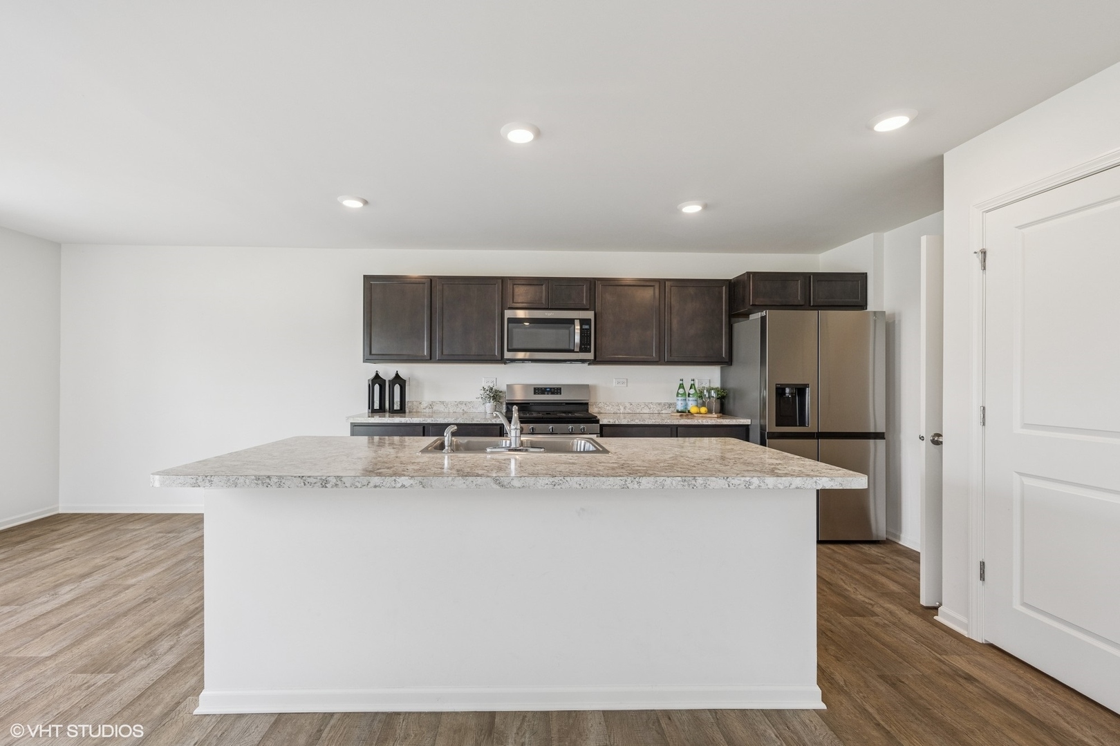 411 Stockton Drive Joliet, IL 60421 - Photo 4 of 29 a large kitchen with stainless steel appliances granite countertop a stove a sink a refrigerator and white cabinets with wooden floor