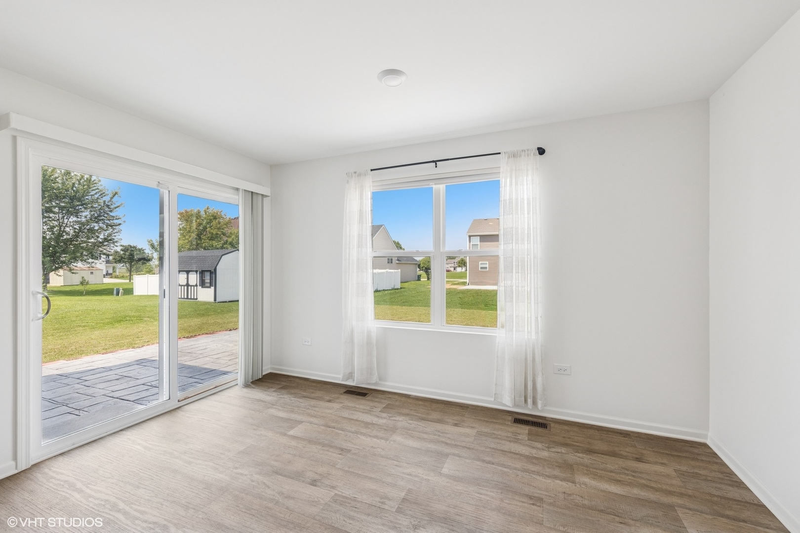 411 Stockton Drive Joliet, IL 60421 - Photo 8 of 29 an empty room with wooden floor and windows