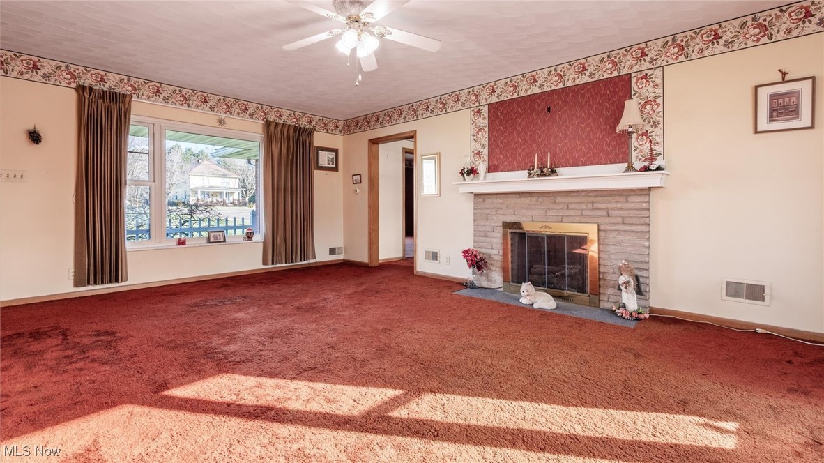 1950 Newark Road Zanesville, OH 43701 - Photo 14 of 39 Unfurnished living room with ceiling fan, carpet, a textured ceiling, and a brick fireplace
