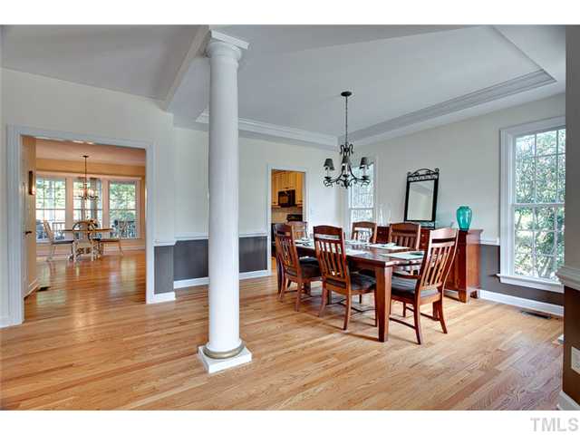4617 Mentone Way Raleigh, NC 27612 - Photo 3 of 23 a dining room with wooden floor a chandelier a wooden table and chairs