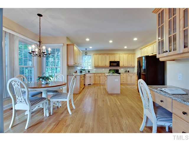 4617 Mentone Way Raleigh, NC 27612 - Photo 8 of 23 a dining room with stainless steel appliances kitchen island granite countertop a dining table chairs and a refrigerator