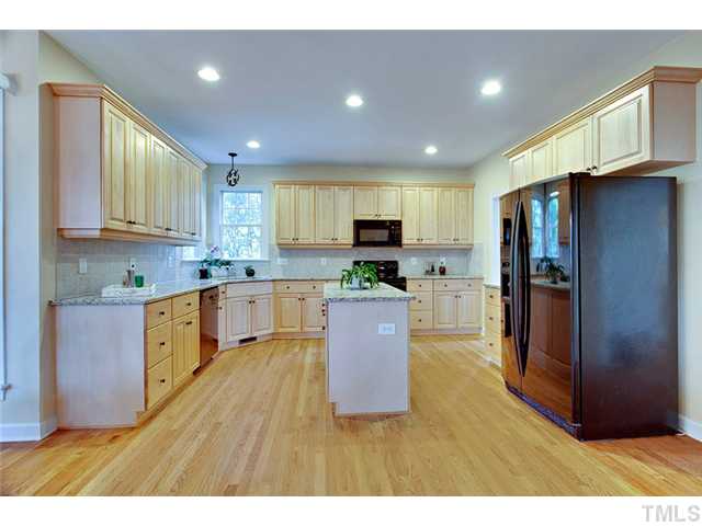 4617 Mentone Way Raleigh, NC 27612 - Photo 10 of 23 a large kitchen with a center island wooden floor stainless steel appliances and cabinets