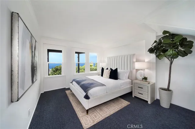 a bedroom with a bed lamp and a potted plant