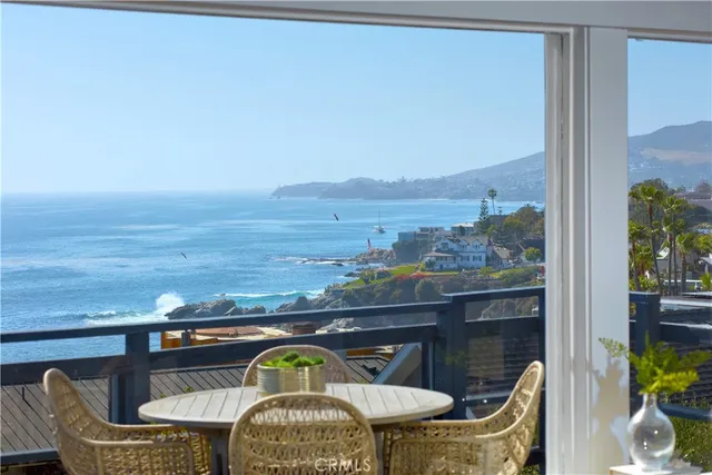 a terrace with a table and chairs next to a yard
