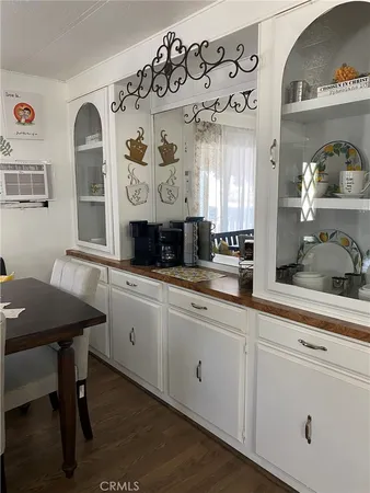 a kitchen with stainless steel appliances granite countertop a stove a sink and white cabinets with wooden floor