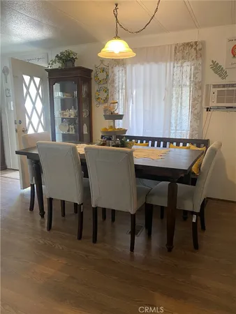 a dining room with furniture a chandelier and wooden floor