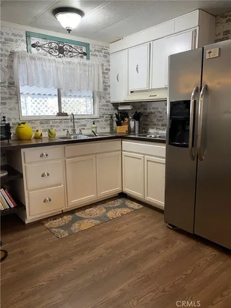 a kitchen with granite countertop a stove a sink and a refrigerator