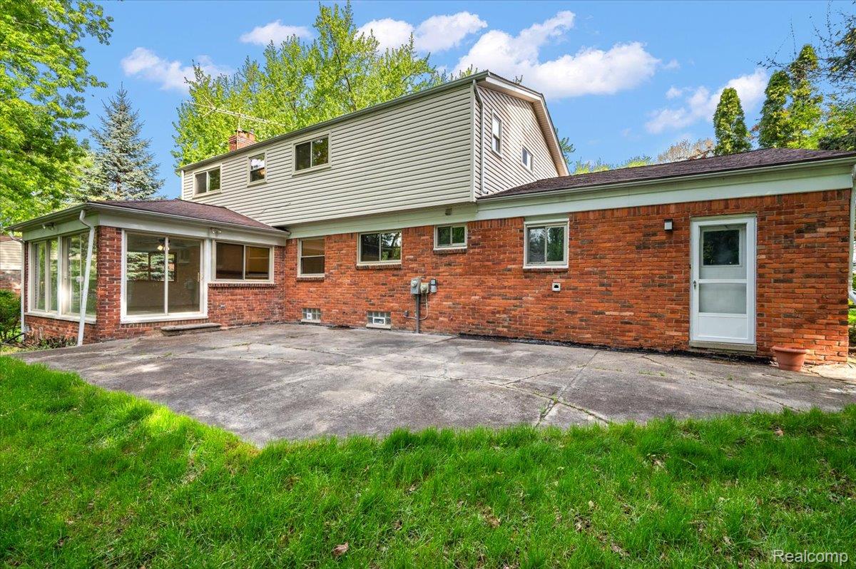 536 Rolling Rock Road Bloomfield Hills, MI 48304 - Photo 41 of 48 Rear view of property featuring a patio, a chimney, brick siding, and a yard