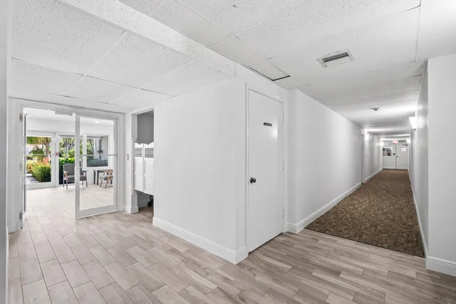 a view of a hallway with wooden floor and a living room