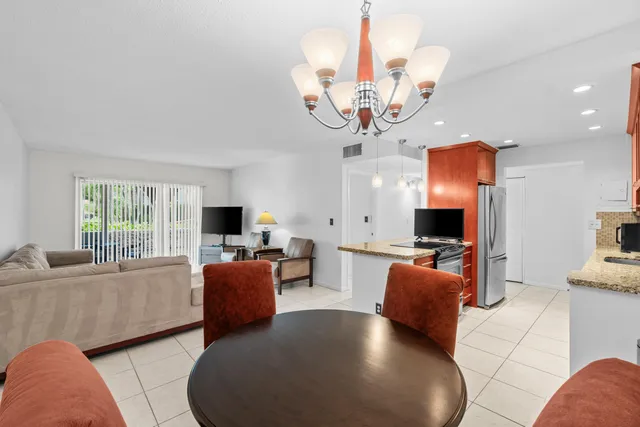 a living room with furniture a chandelier and a flat screen tv