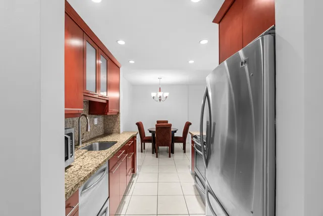 a kitchen with stainless steel appliances granite countertop a refrigerator and a sink