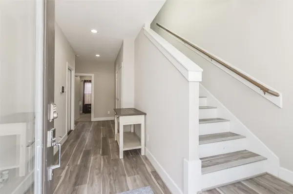 a view of a hallway with wooden floor and staircase