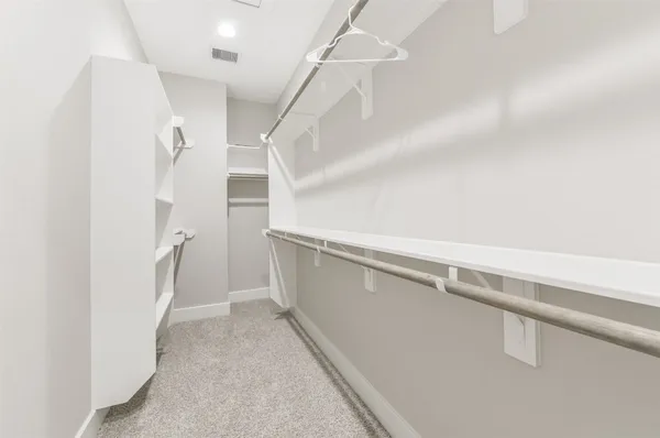 a view of walk in closet with empty racks