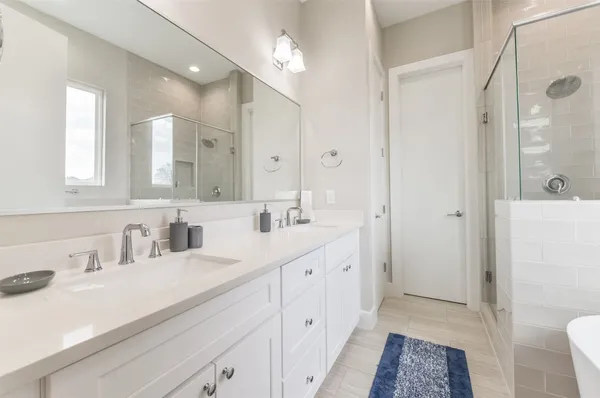 a bathroom with a sink a toilet a shower and a mirror