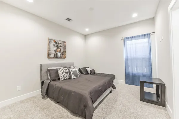 a bedroom with a bed and a night stand