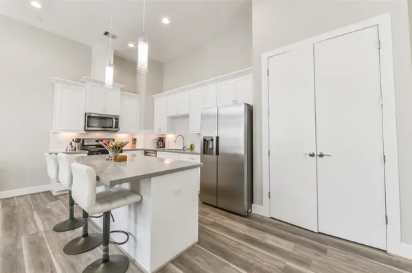 a kitchen with kitchen island white cabinets and stainless steel appliances
