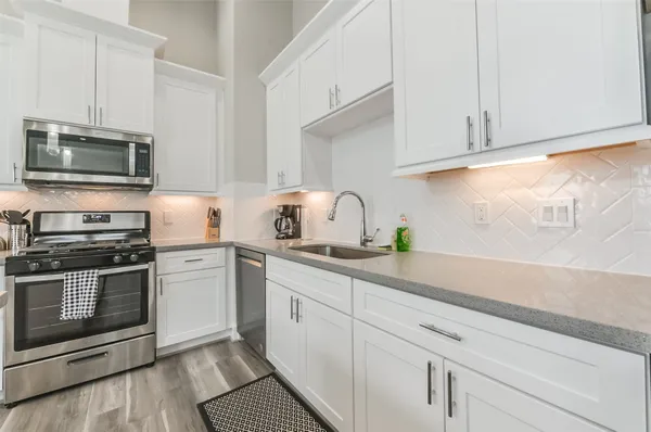 a kitchen with appliances a sink and cabinets