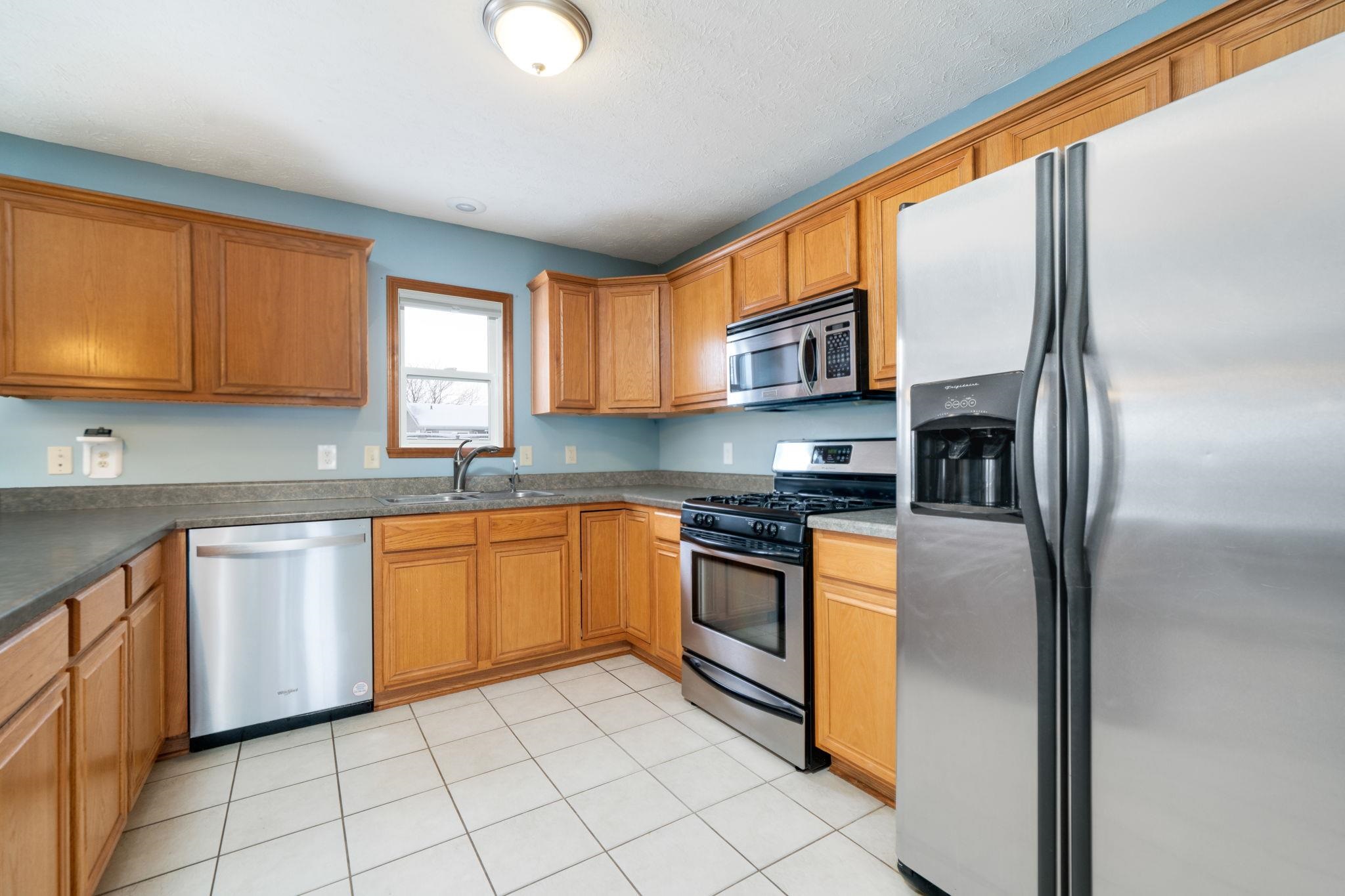 11062 Chicory Ridge Way Roscoe, IL 61073 - Photo 11 of 43 a kitchen with stainless steel appliances granite countertop a refrigerator sink and cabinets