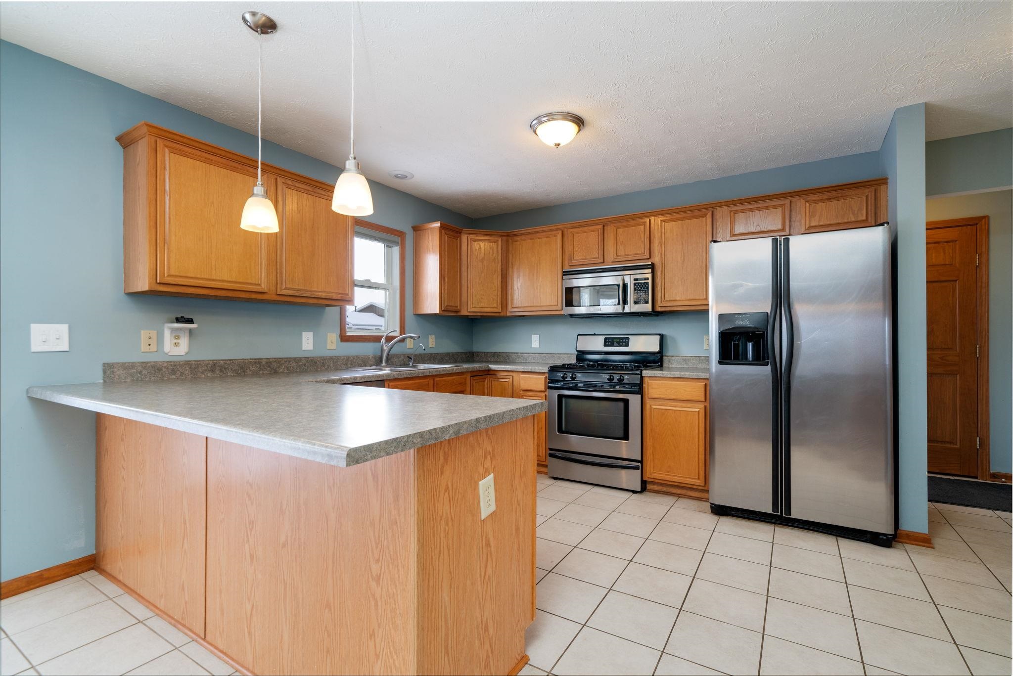 11062 Chicory Ridge Way Roscoe, IL 61073 - Photo 2 of 43 a kitchen with stainless steel appliances granite countertop a sink a stove and a refrigerator