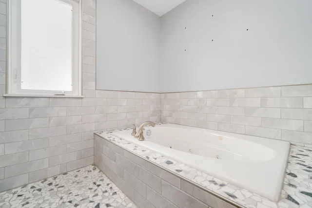 a bathroom with bathtub and window