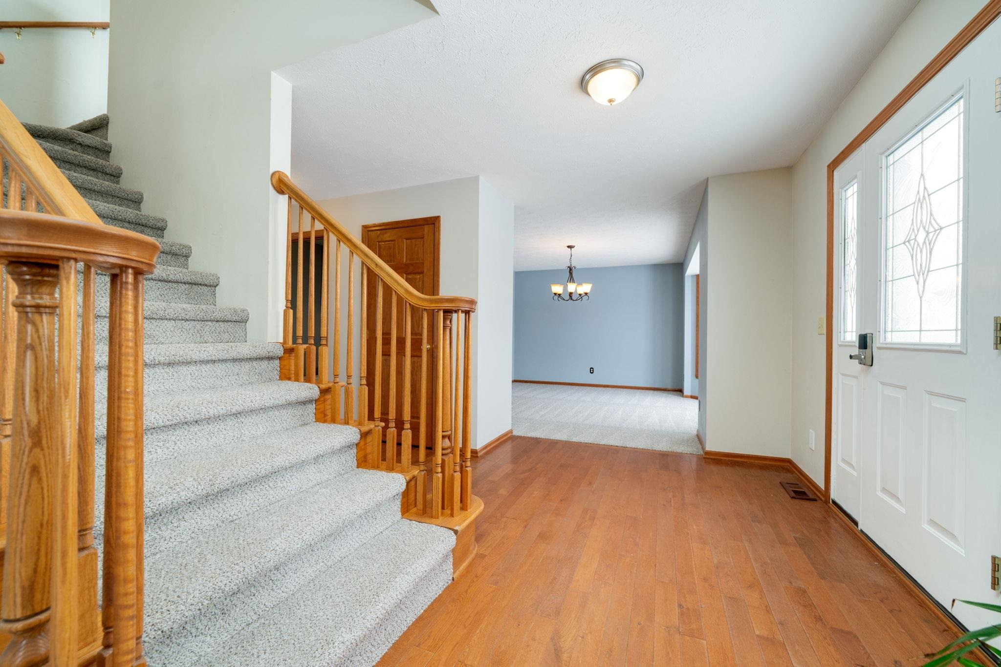 11062 Chicory Ridge Way Roscoe, IL 61073 - Photo 7 of 43 a view of a hallway with wooden floor and staircase